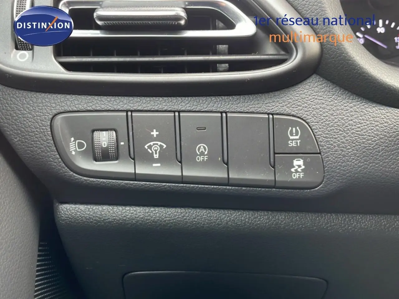 Gros plan sur les commandes de réglage d’éclairage et d’assistance au conducteur dans un Hyundai i30 SW blanc Atlas de 2022.