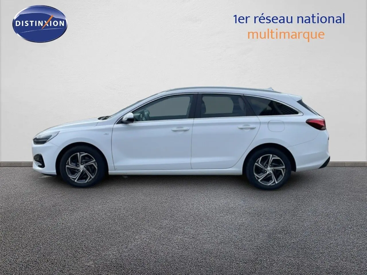 Profil droit d'une Hyundai i30 SW 2022 blanc atlas, break compact avec jantes alliage et vitres teintées.