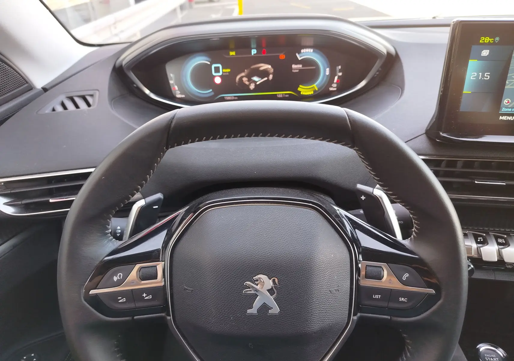 Vue intérieure centrée sur le volant noir du Peugeot 3008 Hybrid 225ch, avec tableau de bord numérique et écran tactile visibles.