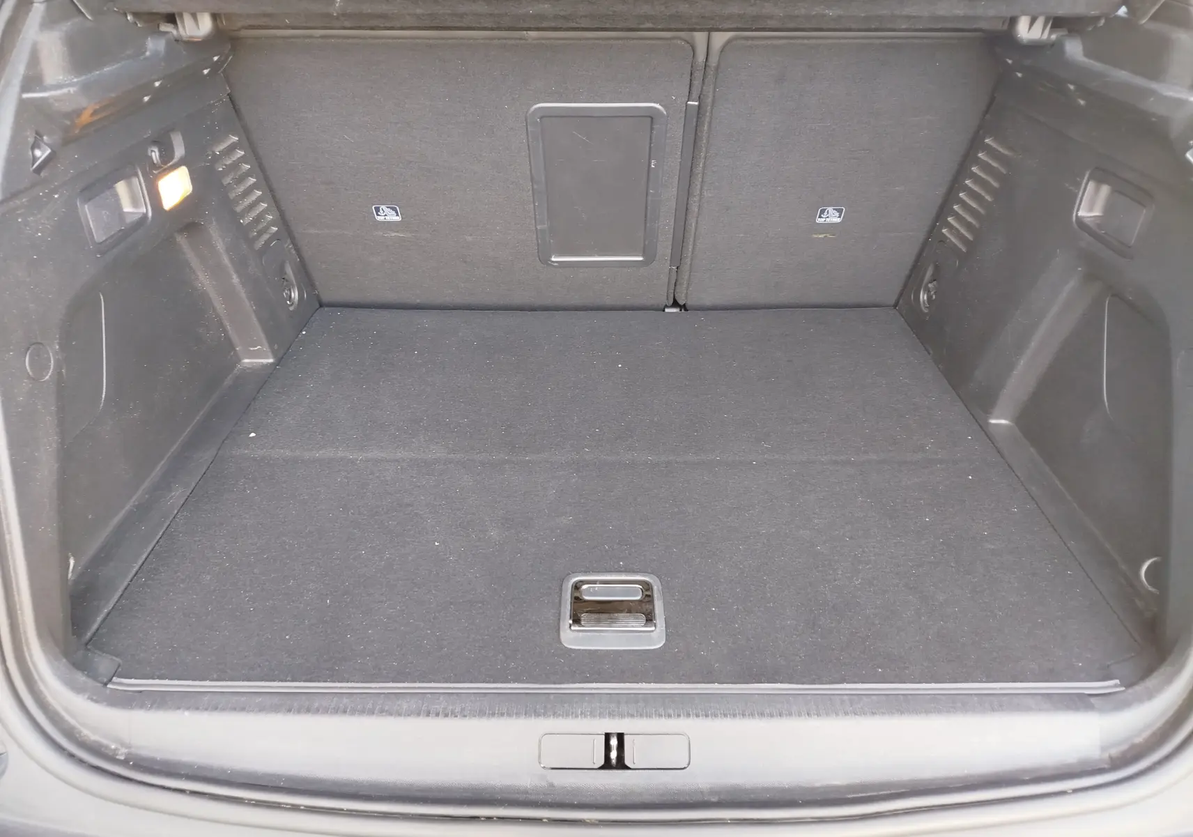 Coffre vide vu de face du Peugeot 3008 Hybrid 225ch Allure e-EAT8, intérieur noir avec éclairage latéral.