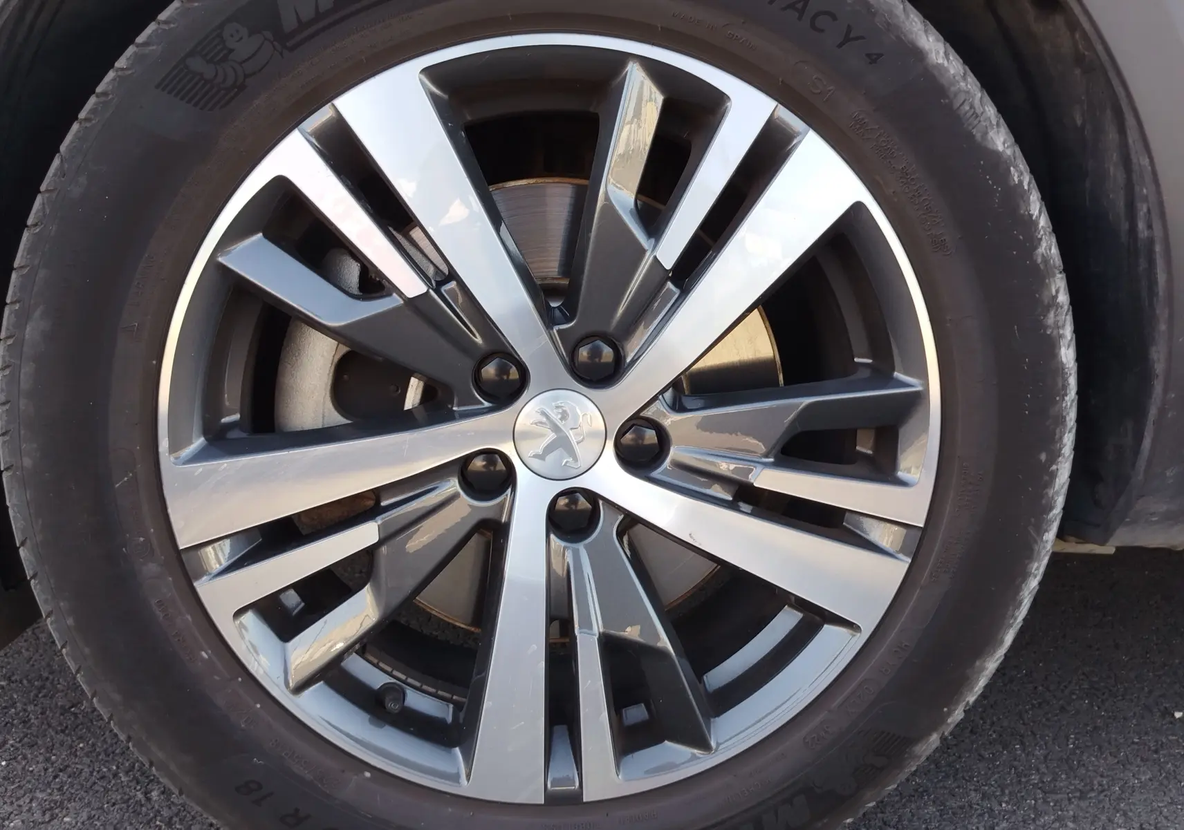 Gros plan sur la jante alliage bicolore du Peugeot 3008 Hybrid 225ch, avec logo lion au centre.