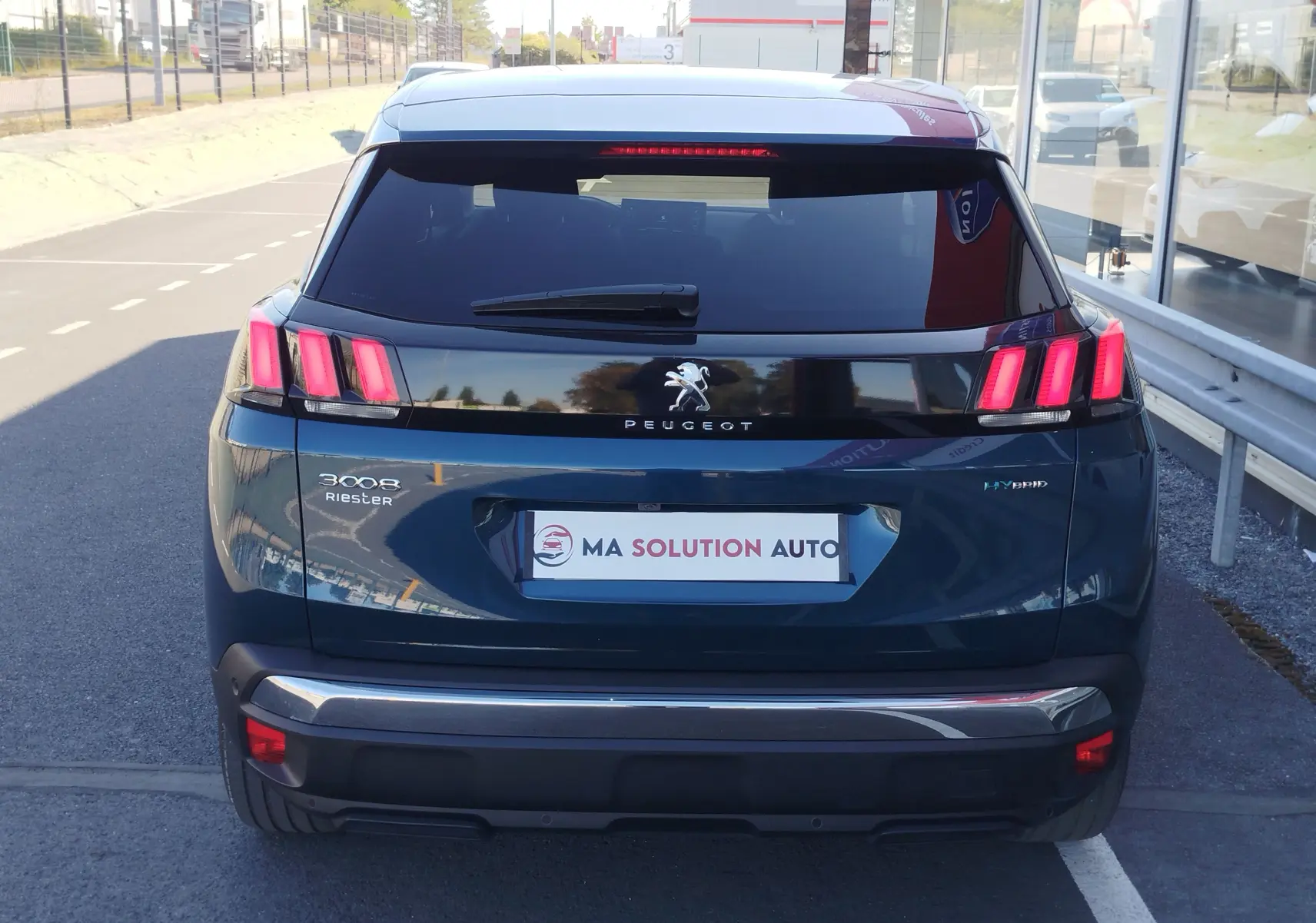 Vue arrière d'un Peugeot 3008 hybride rechargeable bleu Célèbes avec feux arrière à trois griffes rouges allumées.