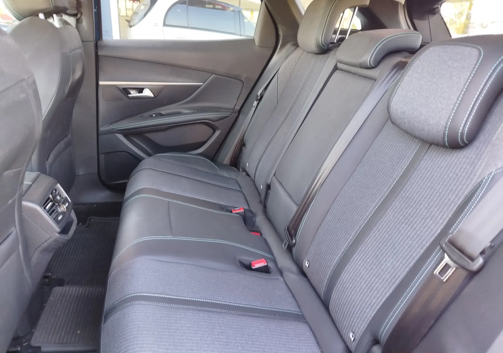 Vue intérieure côté droit des sièges arrière du Peugeot 3008 Hybrid 225ch Allure 2022 avec sellerie tissu et cuir gris foncé.