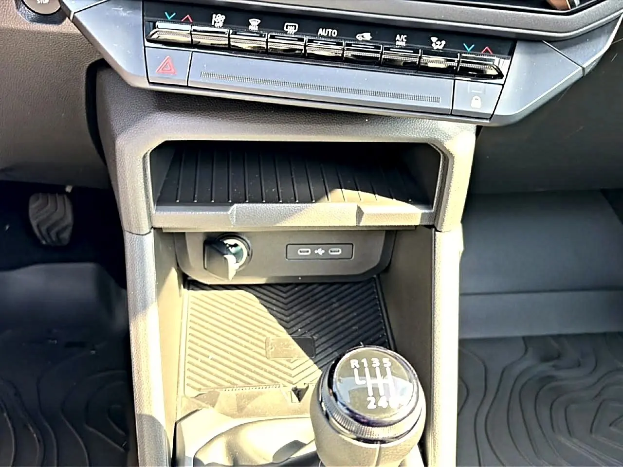Gros plan intérieur sur la console centrale noire du Dacia Bigster 2026, avec levier de vitesse manuel et commandes climatisation.