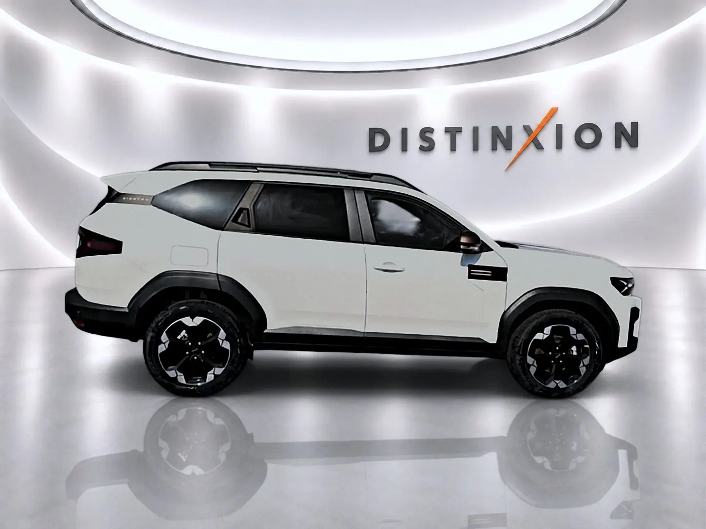 Profil gauche du SUV Dacia Bigster blanc 2026 avec jantes noires et barres de toit visibles en studio lumineux.