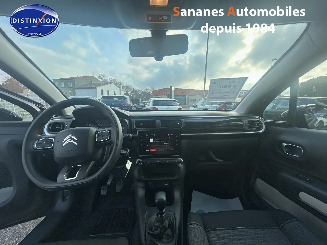 Intérieur de la Citroën C3 2023 gris foncé, vue frontale du tableau de bord avec volant multifonction et écran tactile.