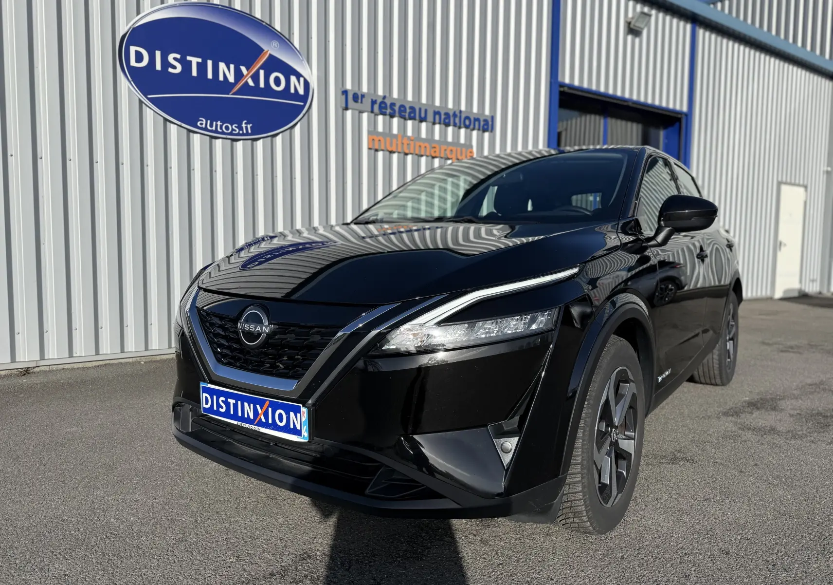 Nissan Qashqai 1.5 E-POWER noir métal, vue 3/4 avant droit, avec calandre V-Motion et phares LED fins.