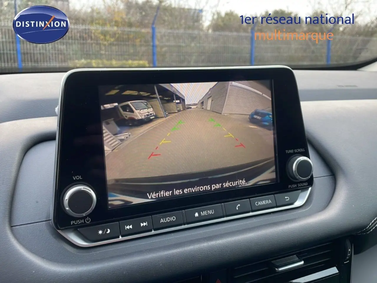 Écran central du Nissan Qashqai 2023 montrant la caméra de recul avec guidage coloré, intérieur noir.