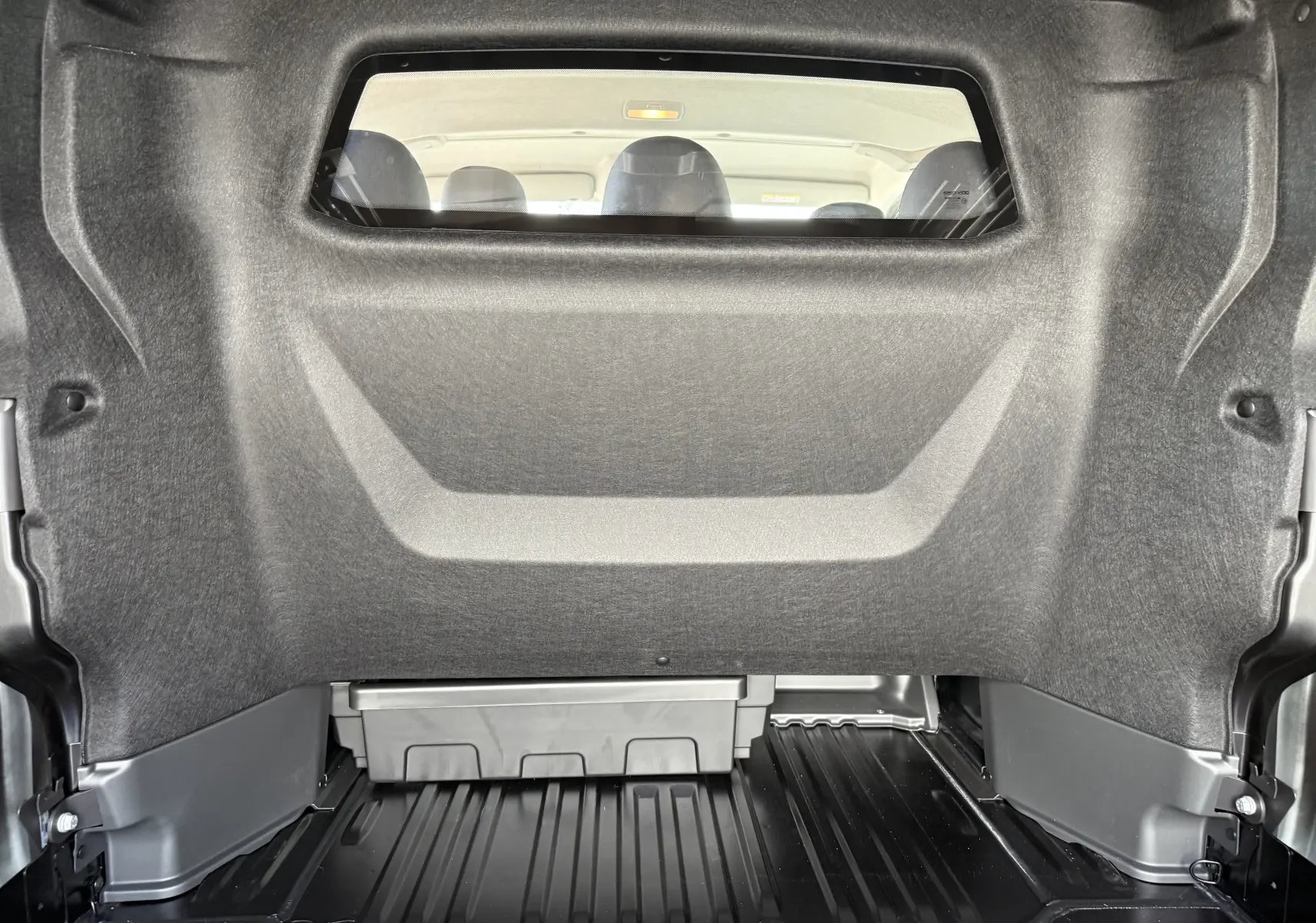 Vue intérieure de la cabine approfondie du Renault Trafic noir, montrant la cloison séparatrice et les sièges arrière.