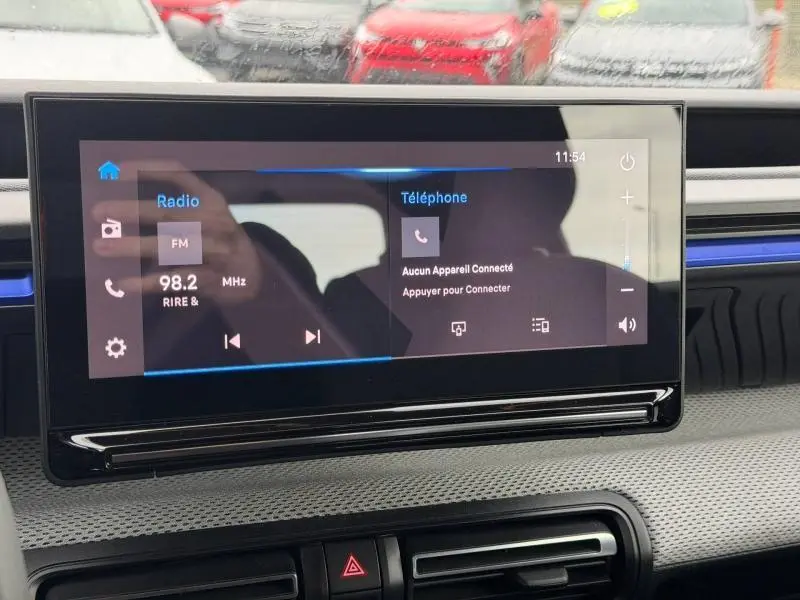 Écran tactile central de la Citroën C3 2025 en gros plan, avec interface radio et téléphone visible.