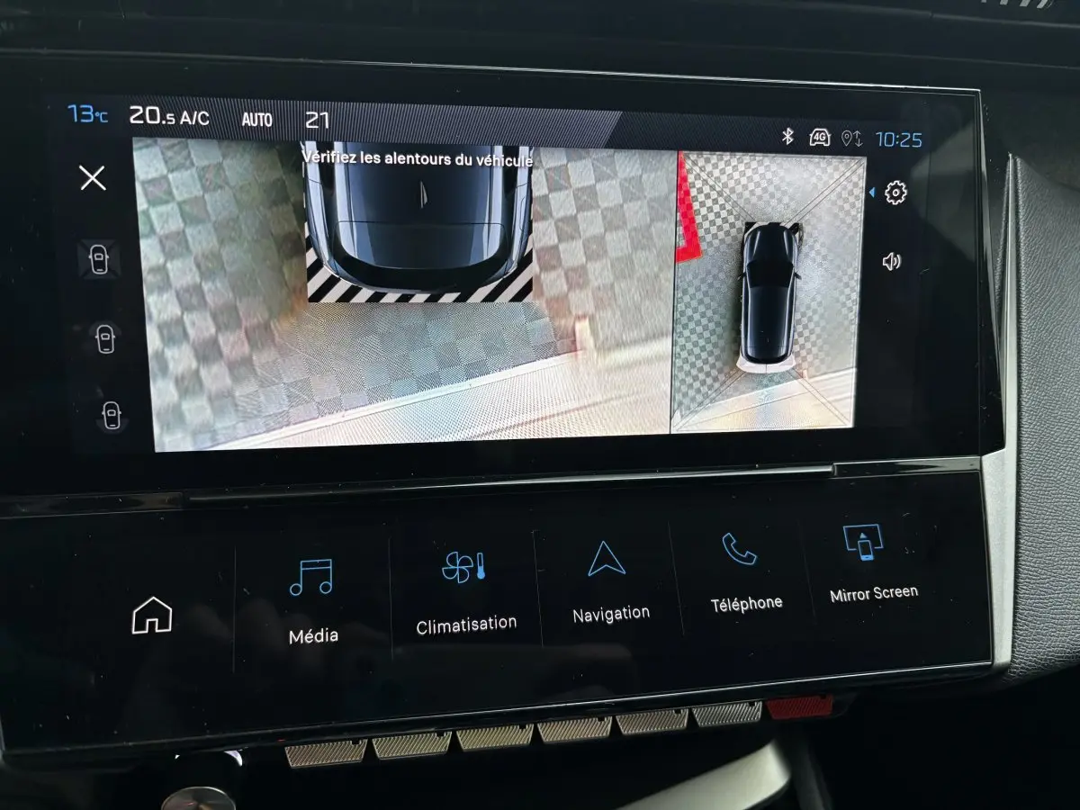 Écran tactile intérieur du Peugeot 308 Hybrid bleu montrant l'aide au stationnement avec vue 360° du véhicule.