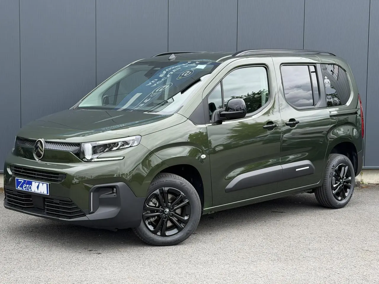 Citroën Berlingo Multispace vert Sirkka en 3/4 avant droit, avec jantes noires et barres de toit noires brillantes.