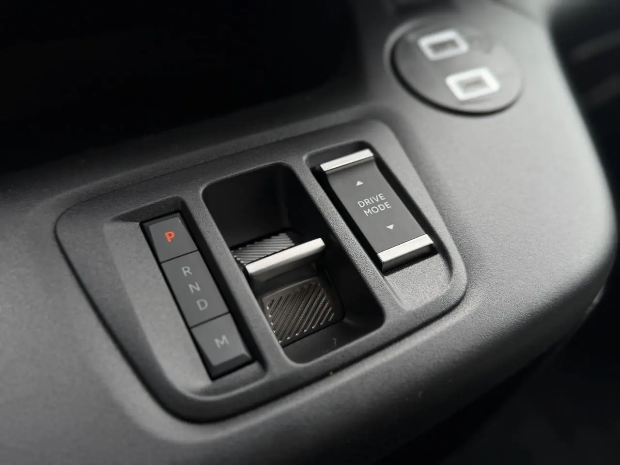 Gros plan sur la console centrale noire du Citroën Berlingo Multispace avec commandes de boîte auto et sélection du mode de conduite.
