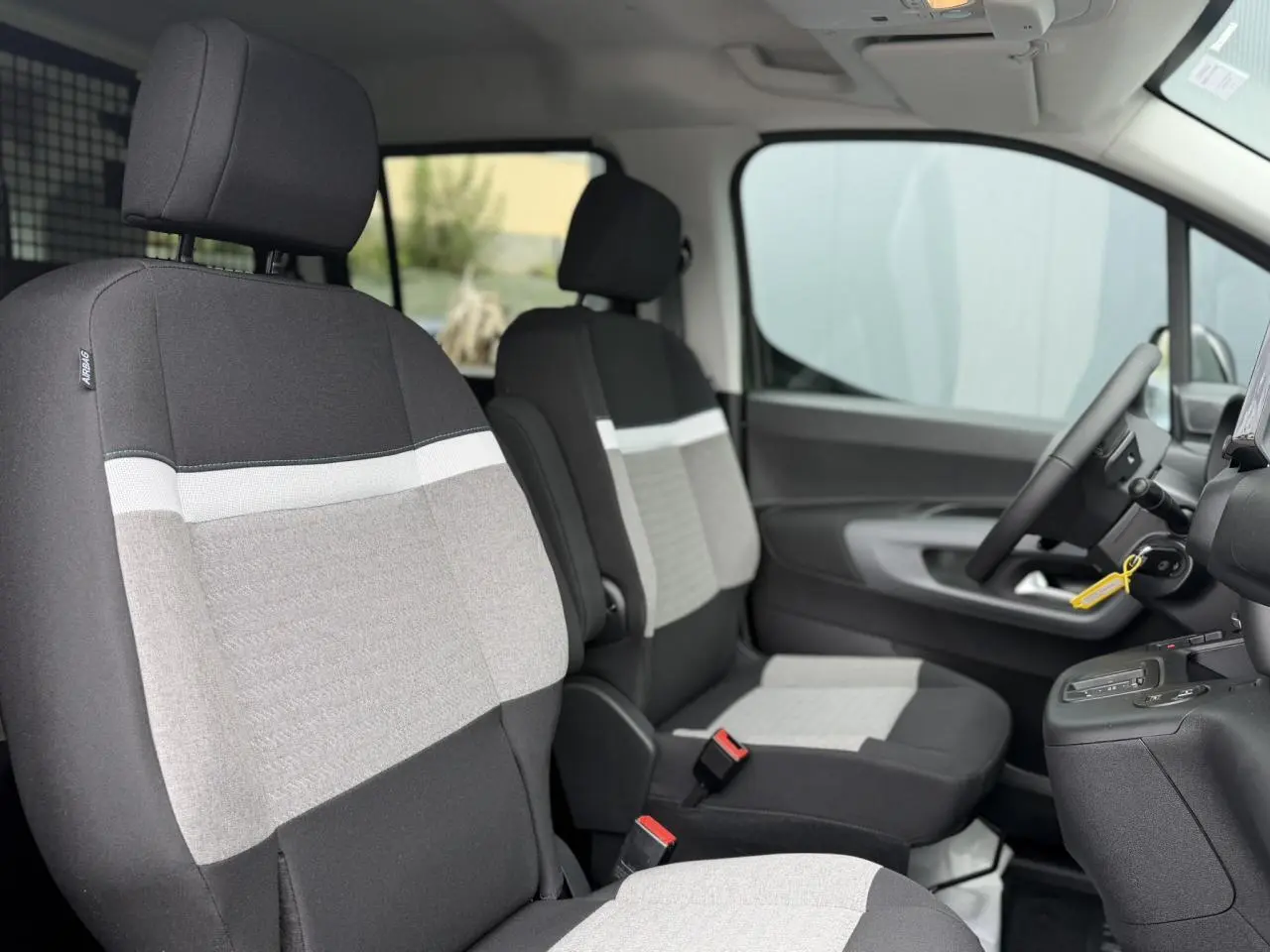 Vue intérieure côté conducteur du Citroën Berlingo Multispace 2026, sièges tissu gris et noir avec détails blancs.
