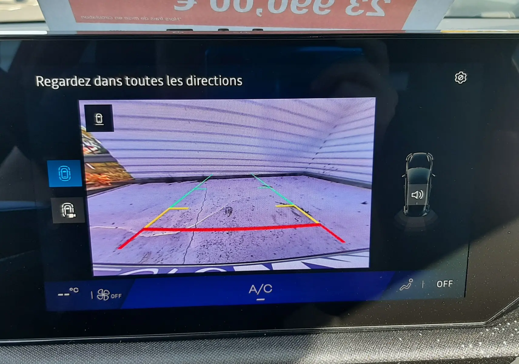 Vue de l'écran intérieur montrant la caméra de recul d'une Renault Clio VI gris Rafale avec guidage coloré.