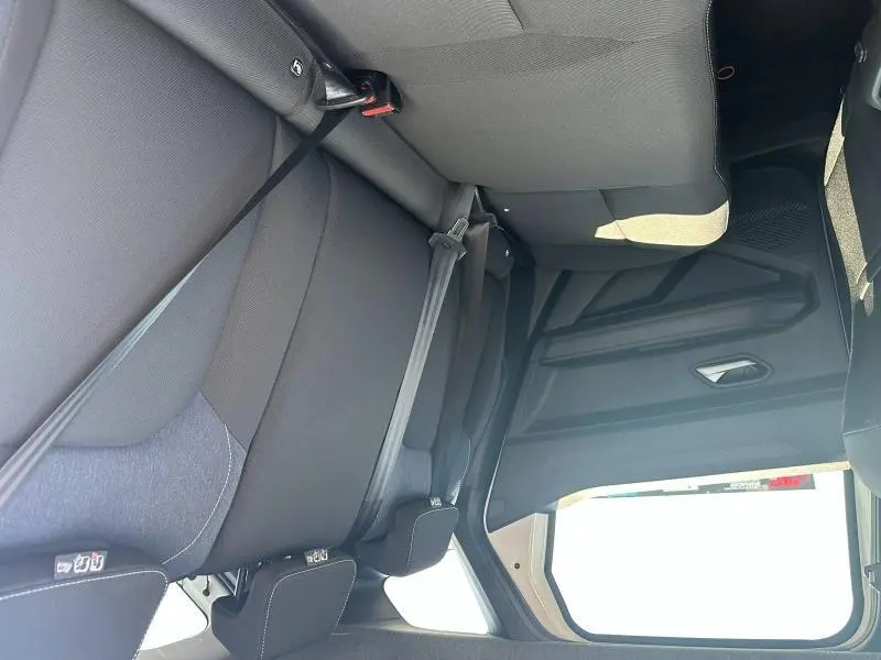 Vue intérieure arrière du Dacia Duster 2025, sièges noirs avec ceinture de sécurité et fixation Isofix visibles.