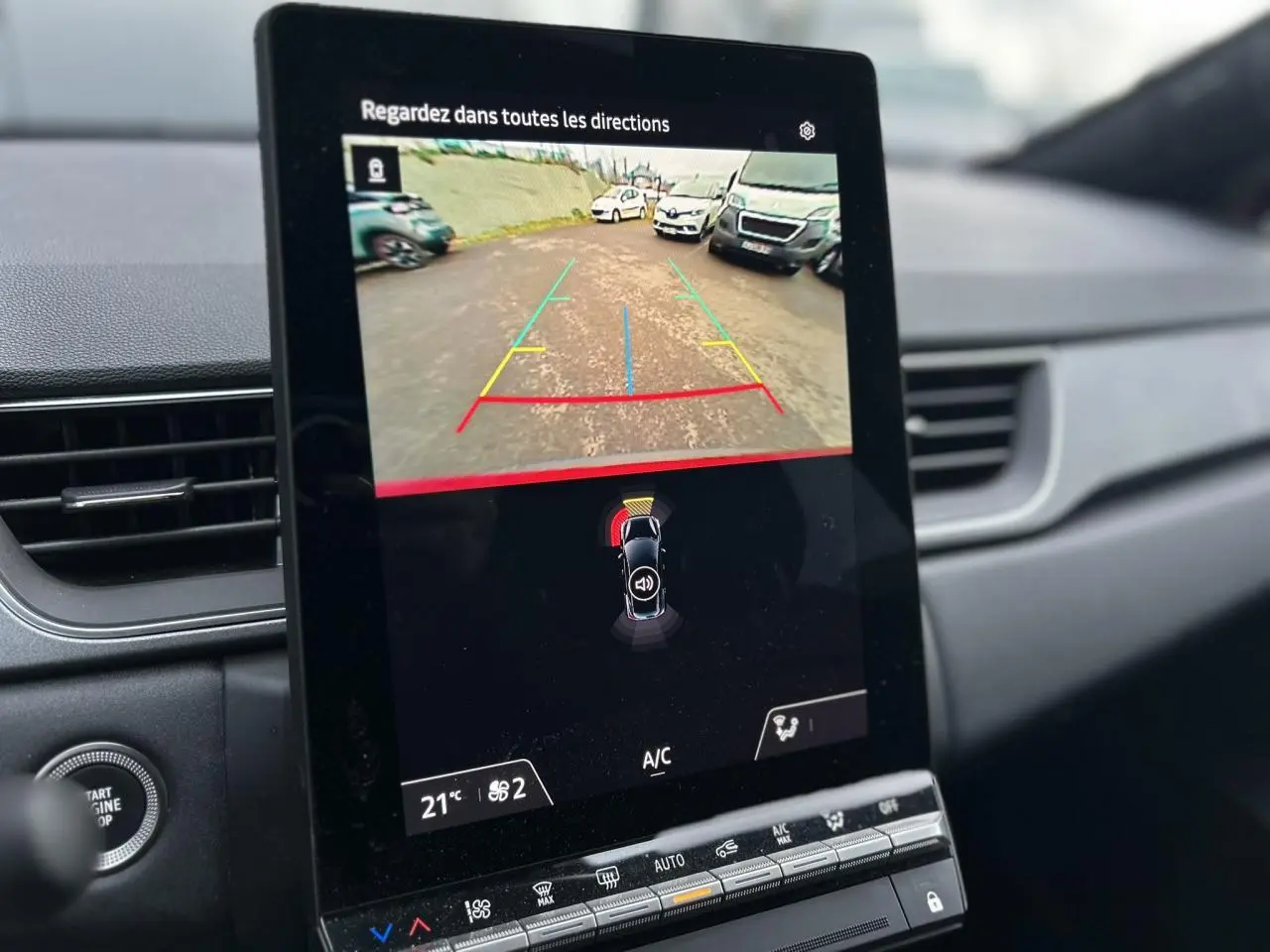 Écran tactile intérieur du Renault Captur 2025 montrant la caméra de recul avec guidage et capteurs de stationnement.