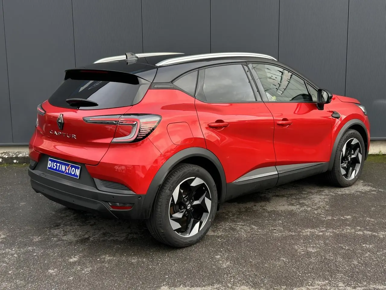 Renault Captur 2025 rouge Flamme et noir, vue 3/4 arrière droit, jantes alu noires diamantées et toit alu.