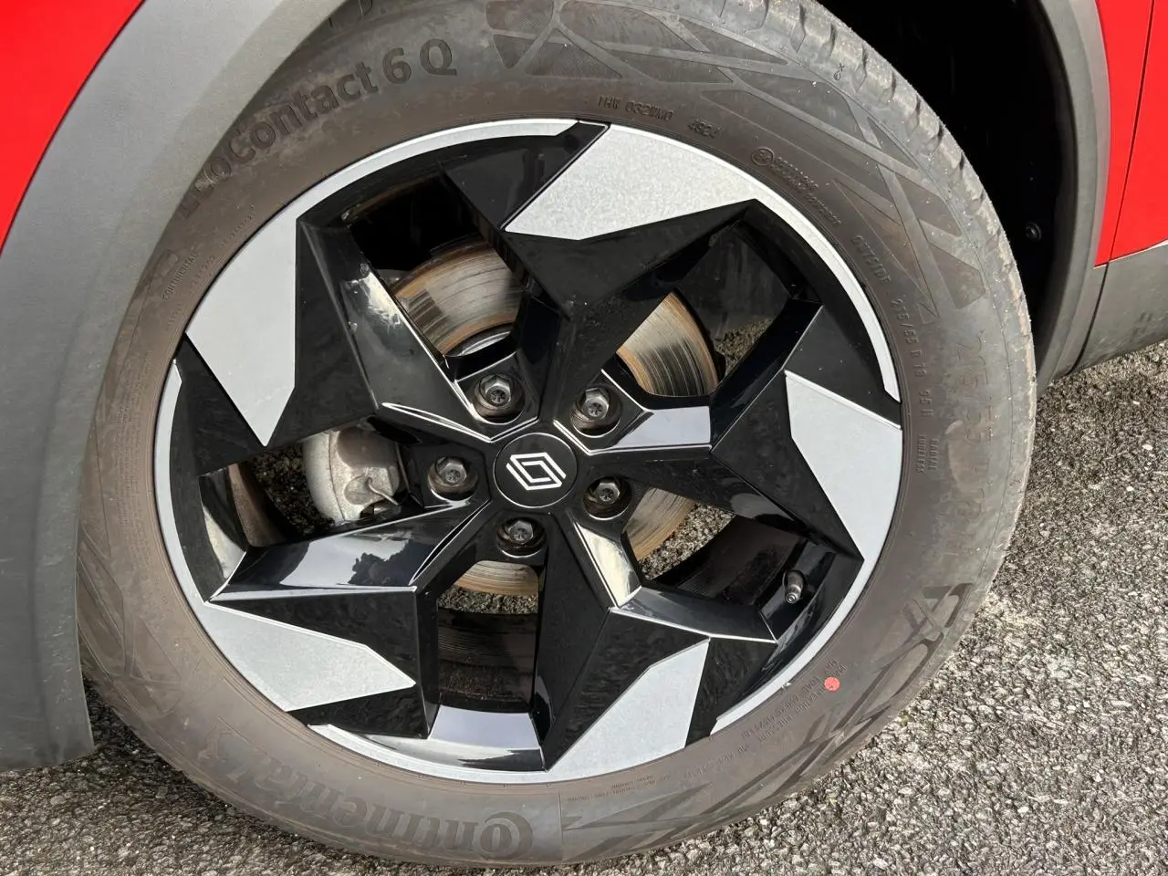 Gros plan sur la jante alu 18 pouces diamantée noire du côté gauche d’un Renault Captur Rouge Flamme.