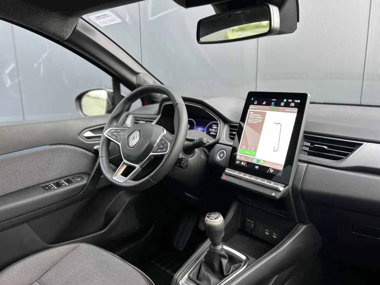 Vue intérieure côté conducteur du Renault Captur 2025, tableau de bord numérique et écran tactile vertical noir.