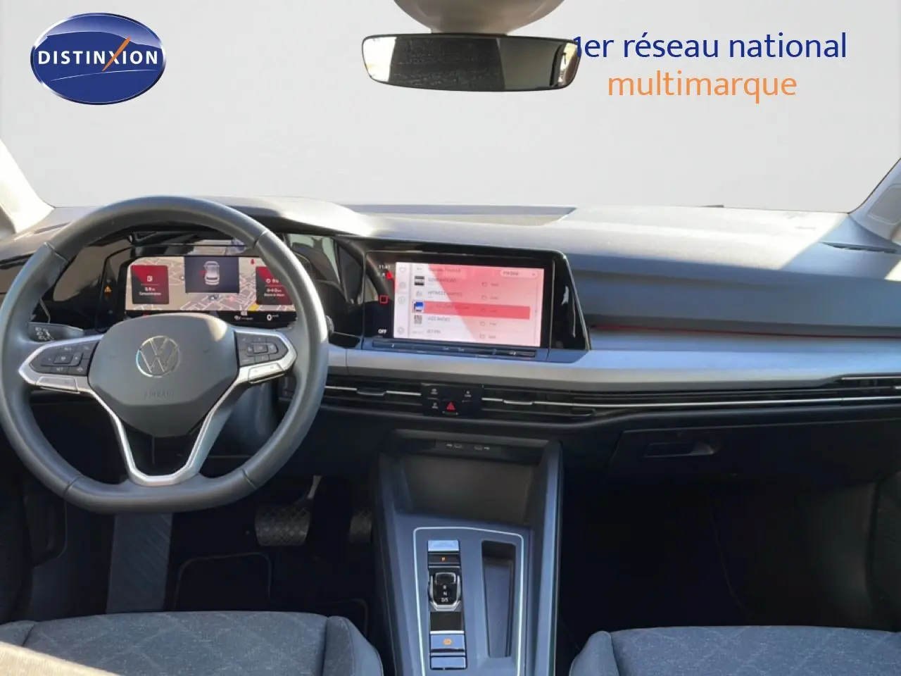 Intérieur de la Volkswagen Golf VIII rouge roi métal, vue frontale sur le tableau de bord et volant multifonction.