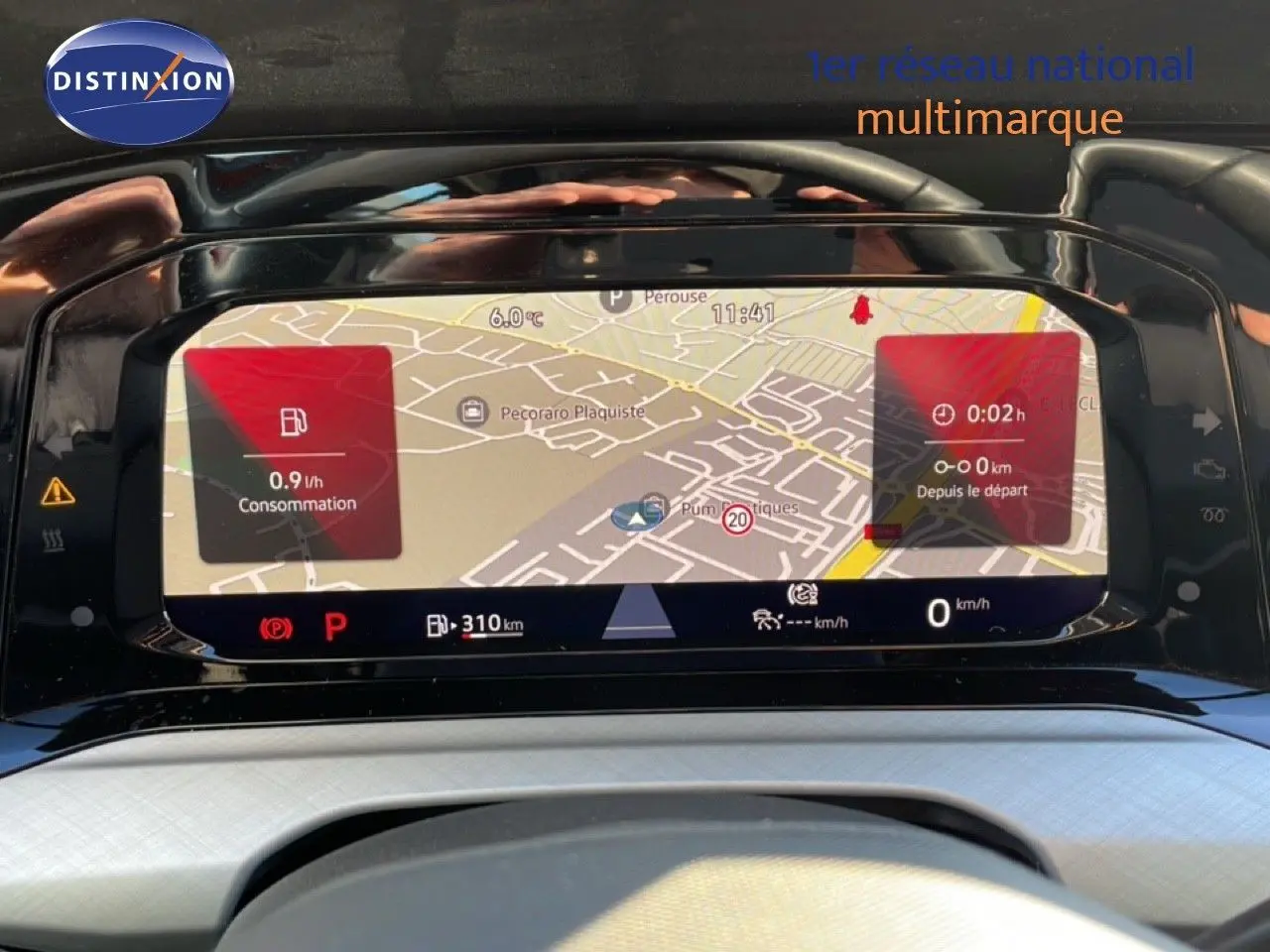 Vue rapprochée de l’écran numérique du tableau de bord de la Volkswagen Golf VIII rouge, affichant la navigation et la consommation.