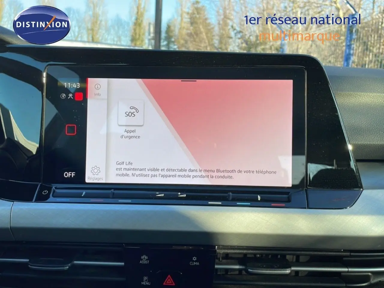 Écran tactile central affichant l'interface d'appel d'urgence dans l'habitacle d'une Volkswagen Golf VIII rouge vue de face.