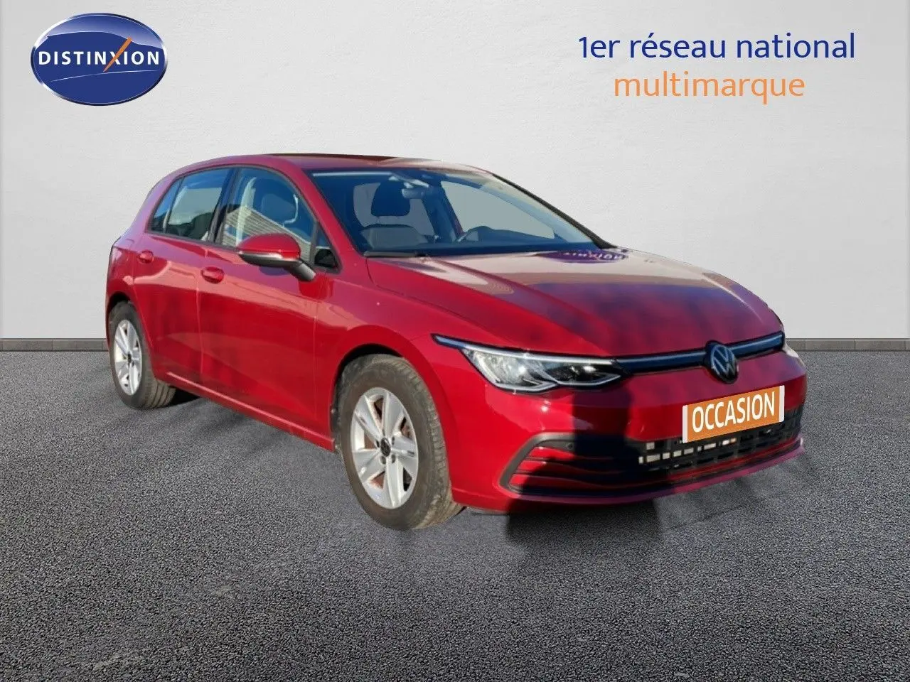 Volkswagen Golf VIII rouge Roi Metal vue 3/4 avant droit sur sol gris, avec plaque occasion visible.