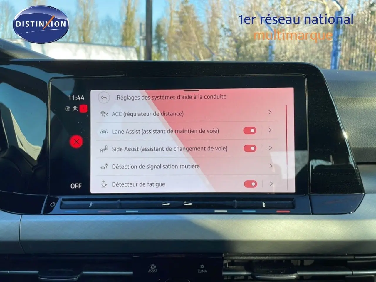 Écran tactile central de la Volkswagen Golf VIII rouge, affichant les réglages des aides à la conduite.