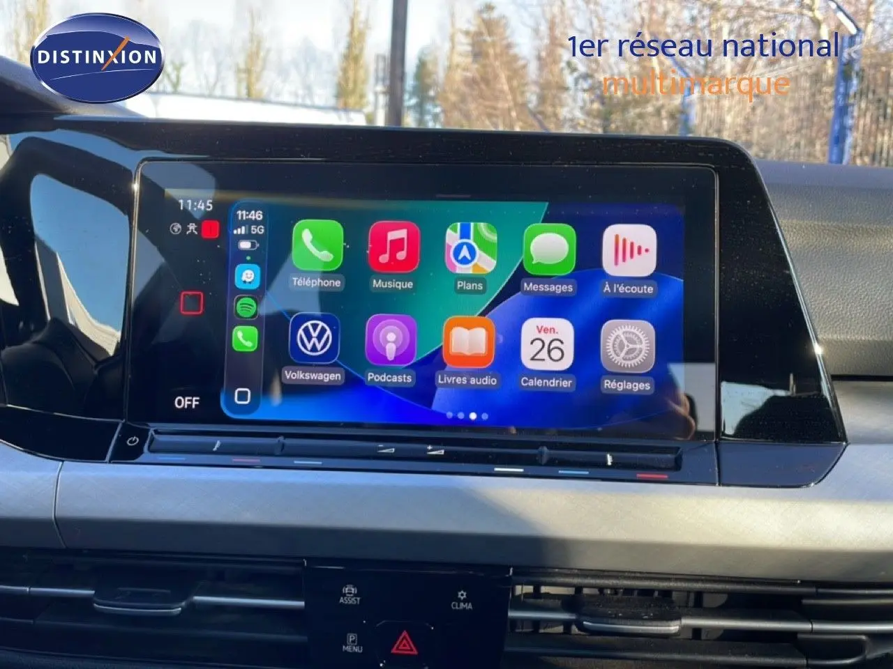 Vue intérieure centrée sur l'écran tactile multimédia de la Volkswagen Golf VIII rouge Roi Metal, affichant les applications connectées.