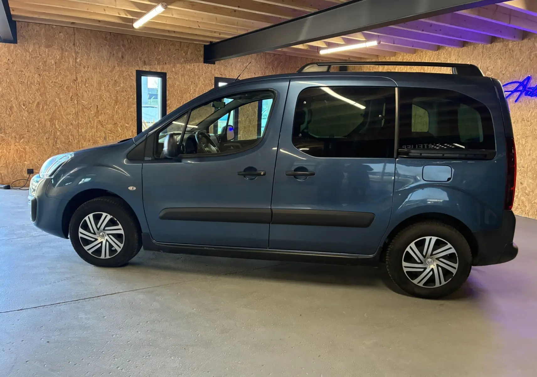 Vue de profil côté gauche d'un Citroën Berlingo Multispace bleu 2017 avec portes latérales coulissantes et jantes alliage.