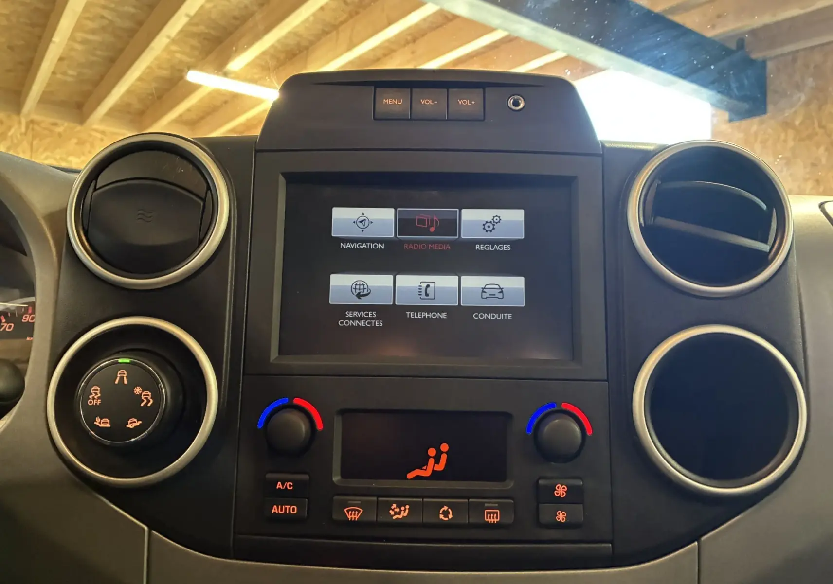 Vue rapprochée du tableau de bord noir du Citroën Berlingo Multispace 2017 avec écran tactile et commandes de climatisation.