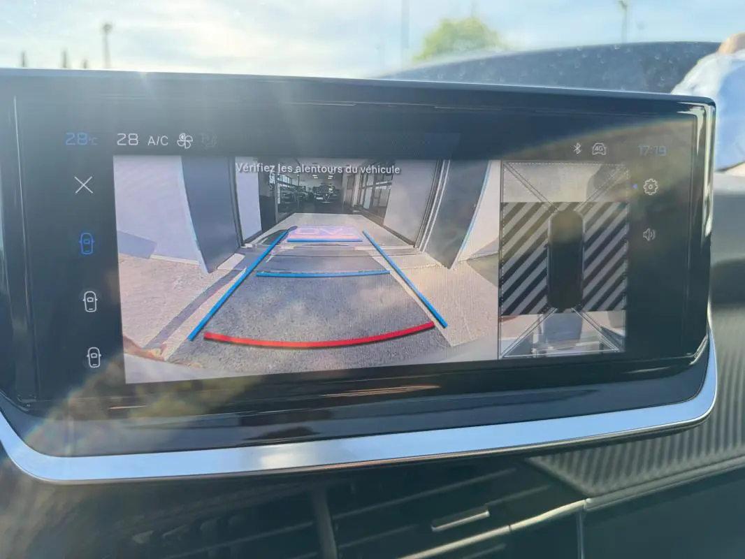 Écran tactile intérieur montrant la caméra de recul avec guidage coloré dans un Peugeot 2008 Hybrid noir.
