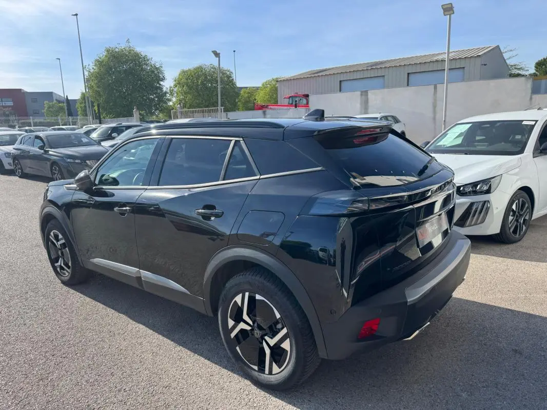 Peugeot 2008 Hybrid noir en 3/4 arrière droit, avec barres de toit, jantes alliage 17 pouces et vitres teintées.
