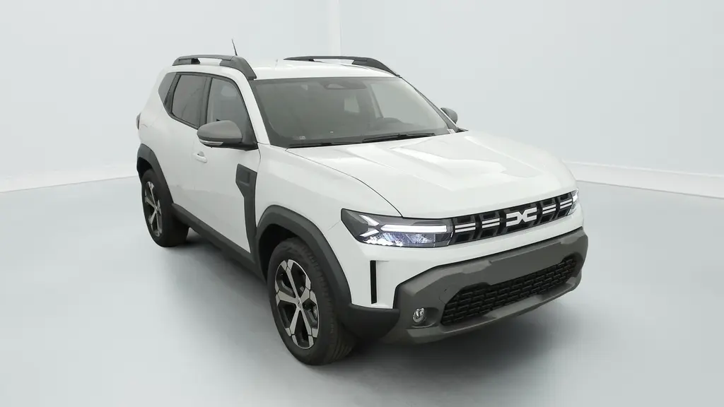 Dacia Duster Mild Hybrid blanc glacier, vue 3/4 avant droit, avec jantes alliage 18'' et barres de toit noires.