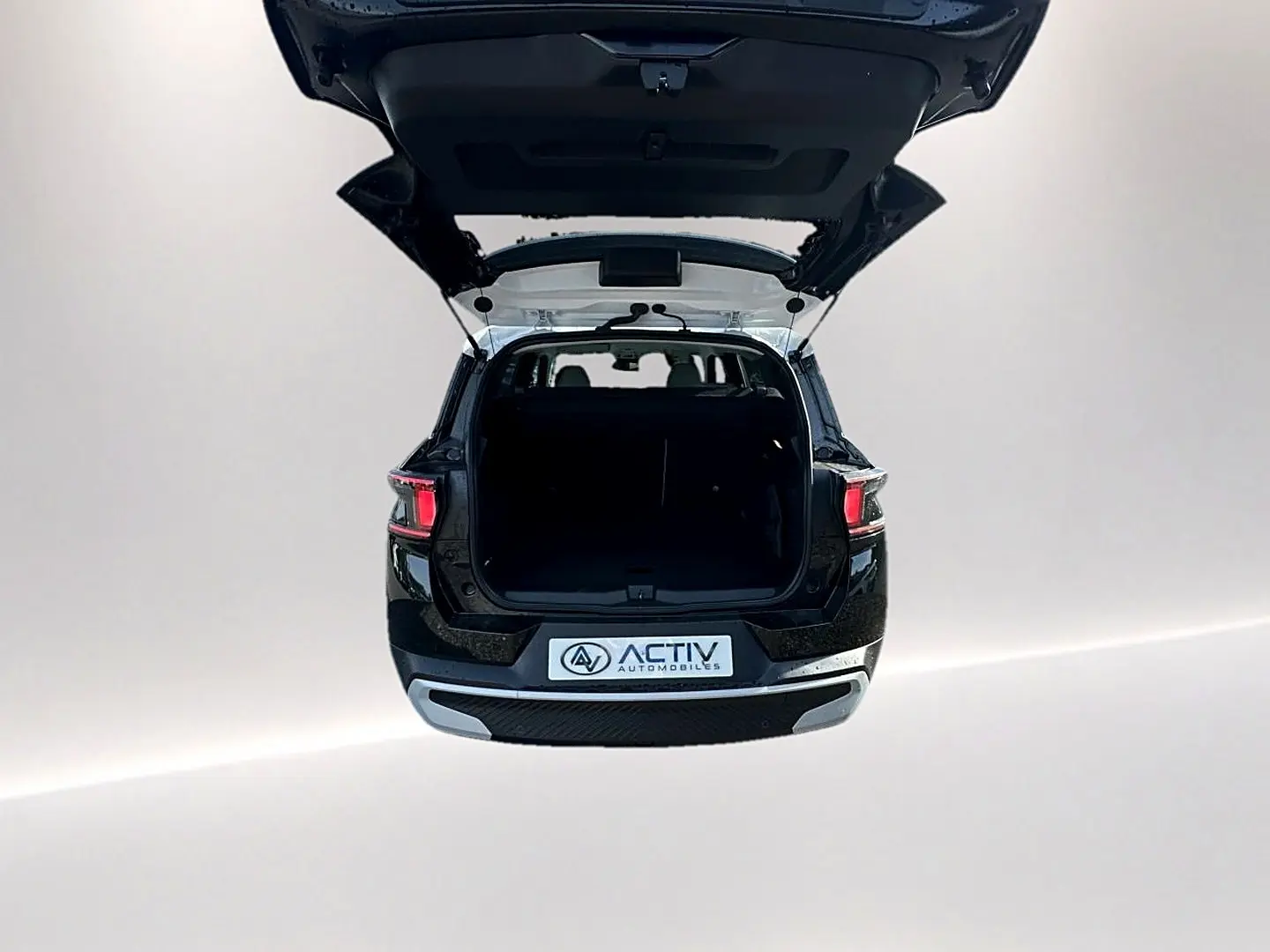 Vue arrière d'un Citroën C3 Aircross noir 2026 avec coffre ouvert et feux arrière allumés.