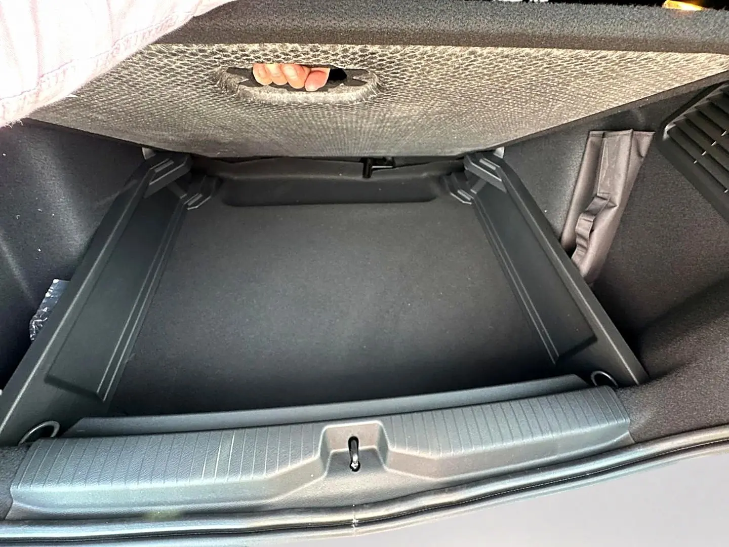 Vue plongeante sur le coffre noir du Citroën C3 Aircross 2026 avec plancher de coffre mobile relevé.