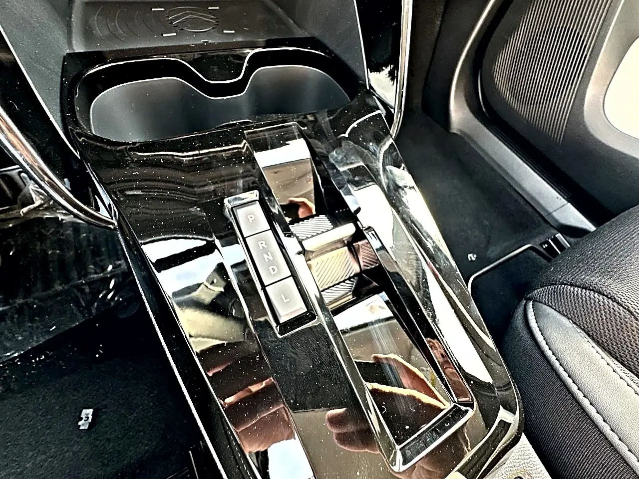Gros plan sur la console centrale noire brillante avec levier de boîte automatique et porte-gobelets du Citroën C3 Aircross.