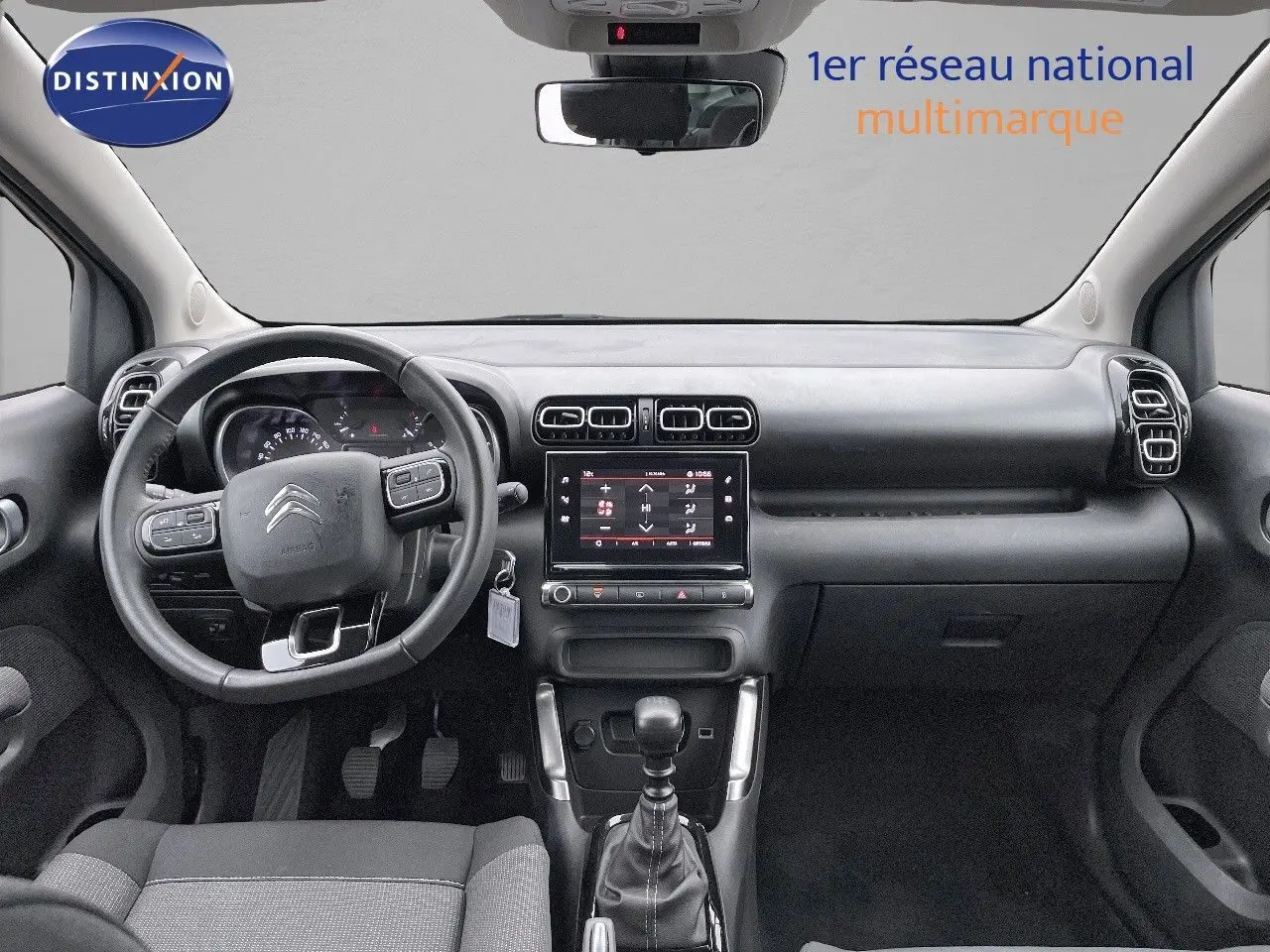 Vue intérieure avant du Citroën C3 Aircross 2023 noir perle, montrant le volant multifonction et la console centrale tactile.