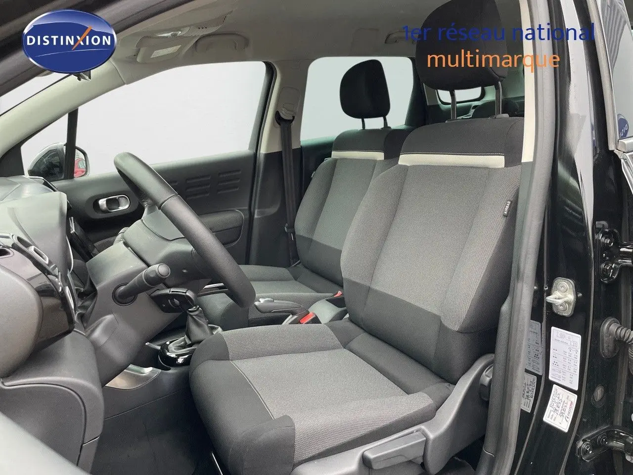Vue intérieure côté conducteur d'une Citroën C3 Aircross 2023 noir perle métal avec sièges tissu gris et noir.