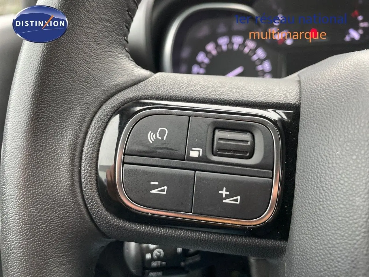 Gros plan sur les commandes du volant d'une Citroën C3 Aircross 2023 noir perle métal, version diesel Shine.