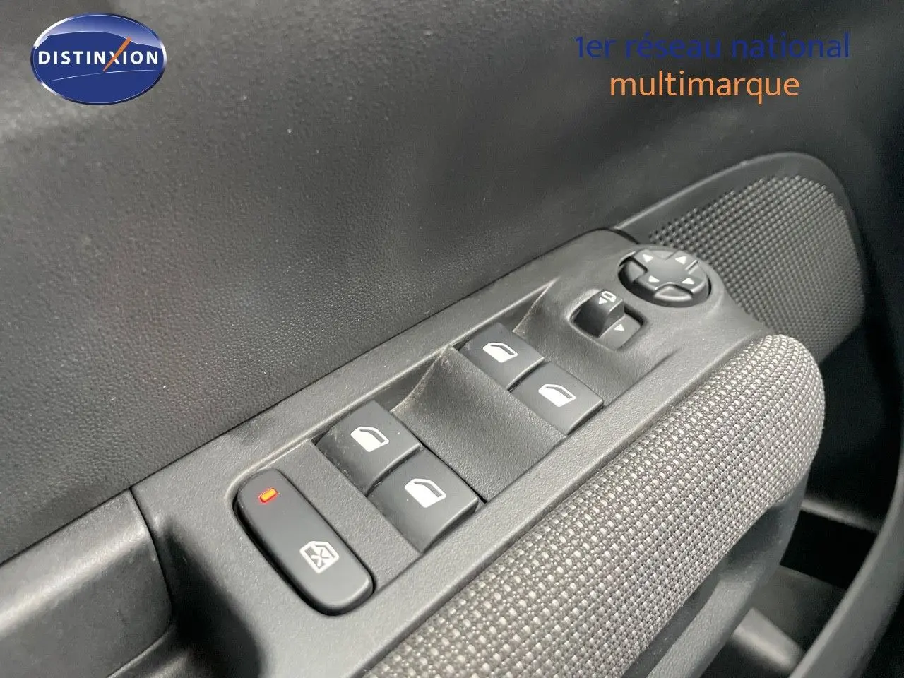 Gros plan sur les commandes des vitres électriques côté conducteur d'une Citroën C3 Aircross 2023 noir perle métal.