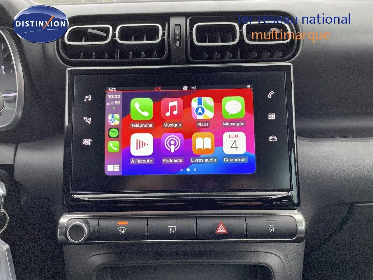 Écran tactile central avec interface Apple CarPlay sur tableau de bord noir d'une Citroën C3 Aircross 2023.