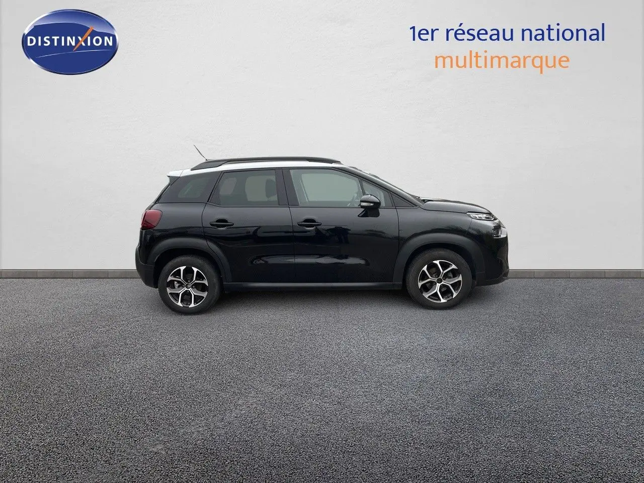 Profil côté gauche d'un Citroën C3 Aircross noir perle métal avec jantes bi-ton et toit blanc sur fond neutre.
