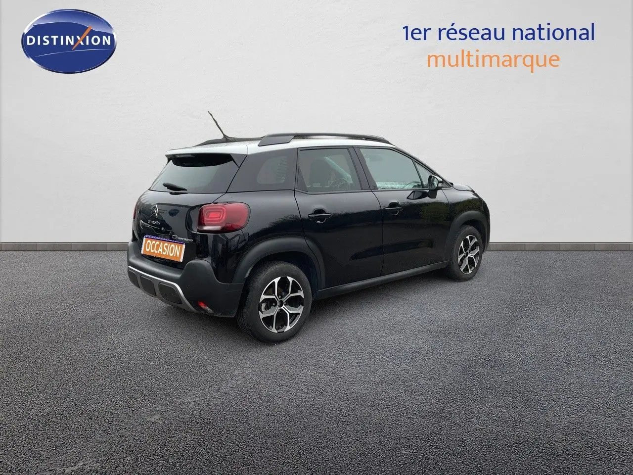 Vue 3/4 arrière droite d'une Citroën C3 Aircross noire perle métal avec jantes biton et toit blanc.