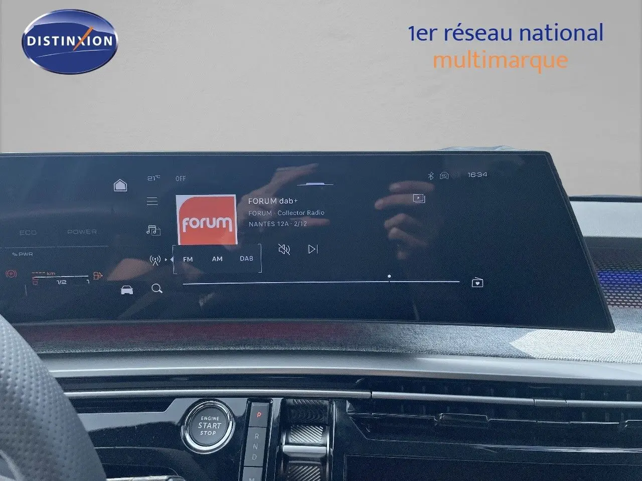 Tableau de bord du Peugeot 5008 Hybrid 2025 avec écran tactile central affichant une radio numérique, vue intérieure frontale.