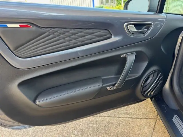 Coffre avant ouvert de l'Alpine A110 1.8T 252 Légende gris acier Heritage, montrant rangement avec trousse de secours et accessoires.