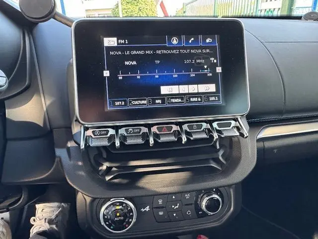 Vue rapprochée de la planche de bord côté passager de l'Alpine A110 gris acier avec surpiqûres bleues et aérateurs ronds chrome.