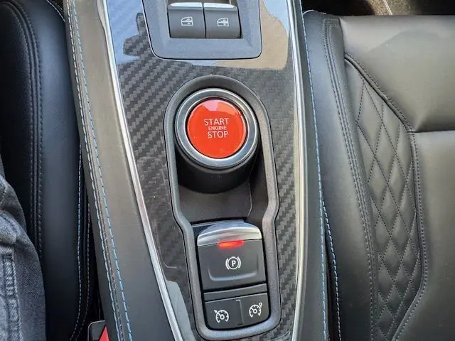 Vue rapprochée de la porte intérieure côté droit de l'Alpine A110 gris acier avec surpiqûres et drapeau tricolore.