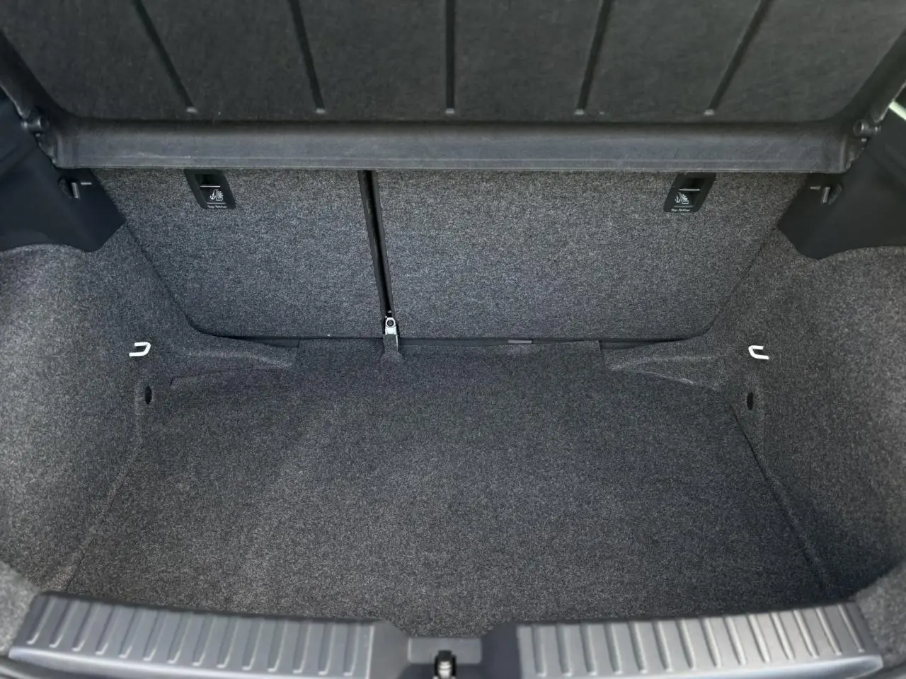 Coffre vide de la SEAT IBIZA TSI 115 Xcellence 2025, vue intérieure montrant la moquette grise et les fixations ISOFIX.